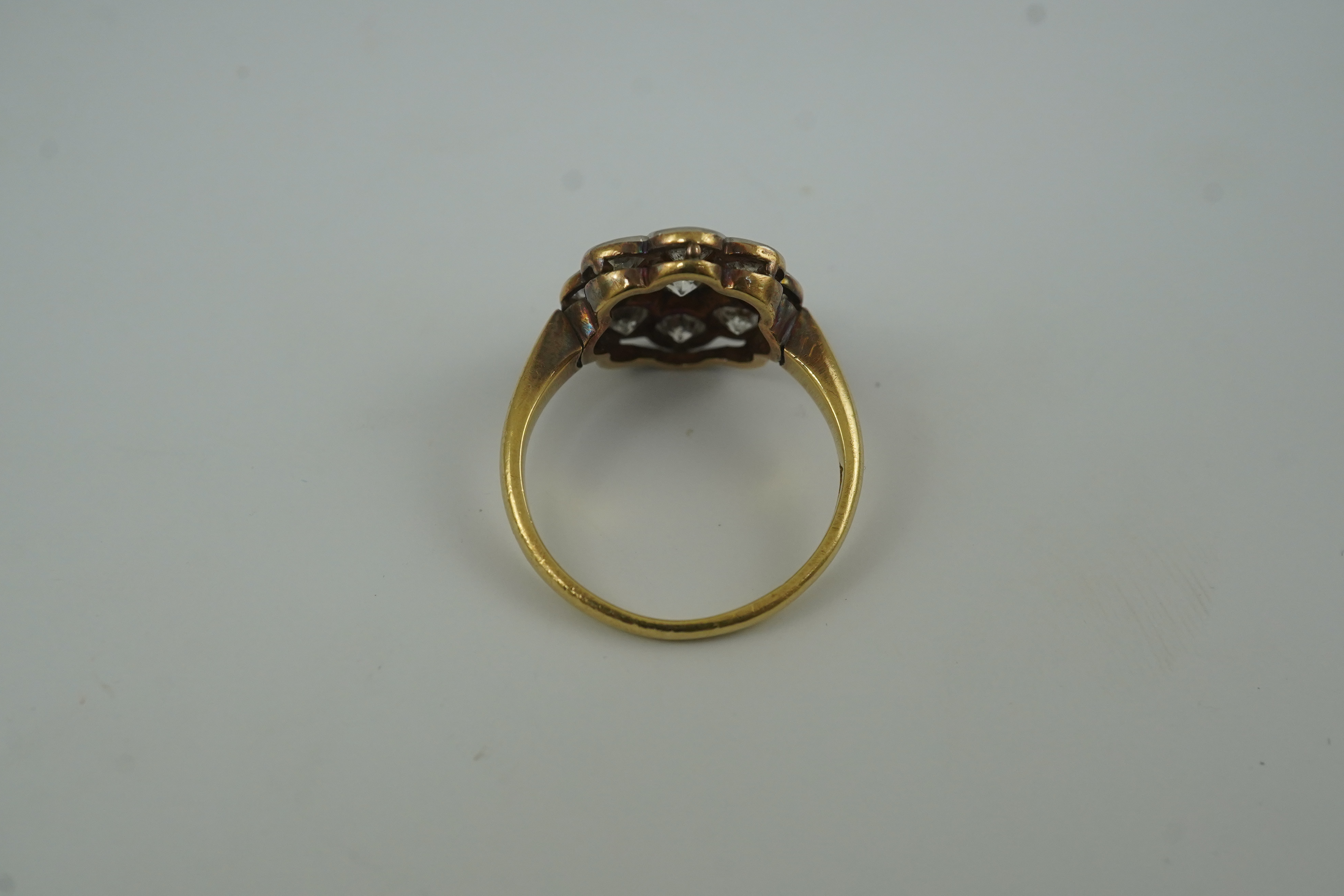 A mid 20th century 18ct gold and nine stone diamond set flower head cluster ring
